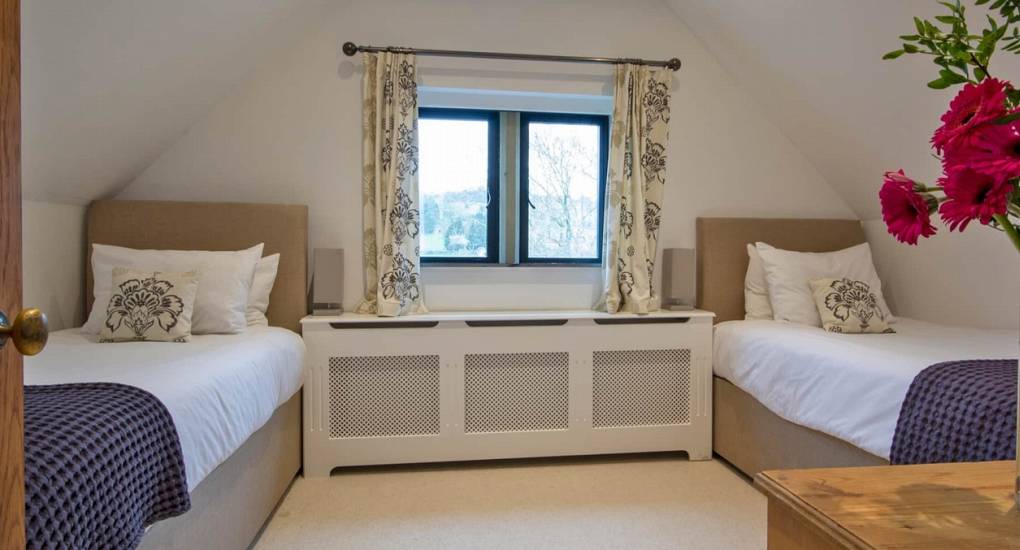 Twin bedroom at Godfrey Manor luxury hen accommodation, featuring comfortable beds and scenic Peak District views.