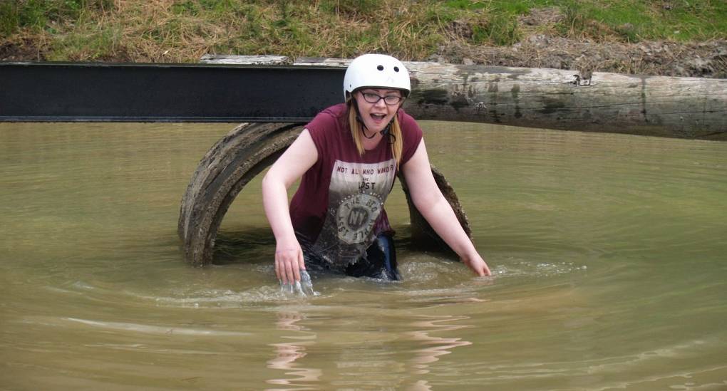 Braving the cold water. Hen taking part in the Assault Course hen party activity