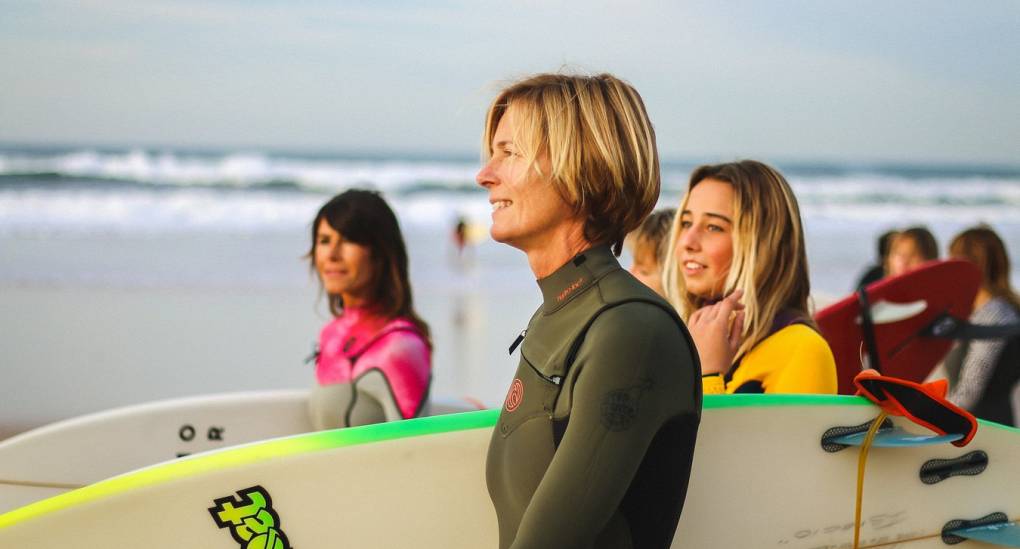 Instructor taking out group of hens for a surf lesson
