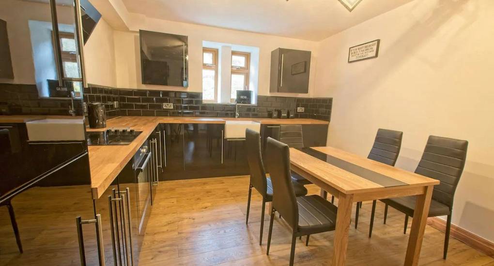 The kitchen area with standard kitchen accessories and appliances