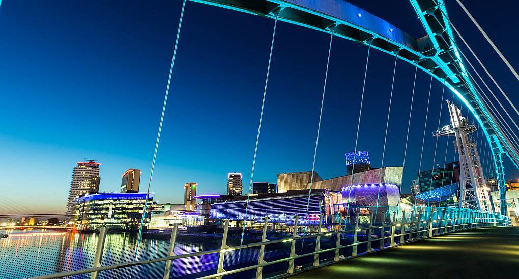 Illuminated MediaCityUK footbridge at Salford Quays at night, prime waterfront location for a Manchester stag do.