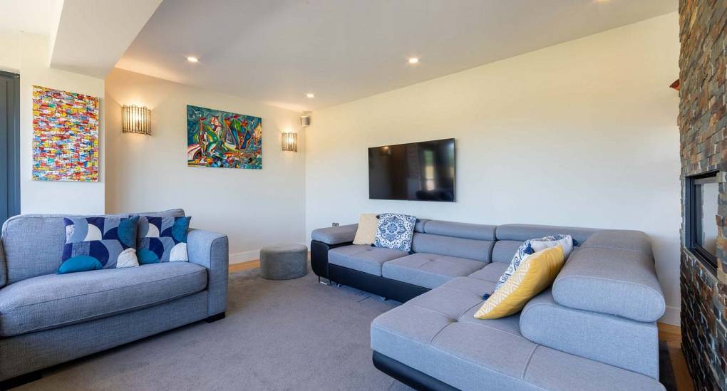 Large lounge at Retreat 12 offering a fire place and TV for movie nights