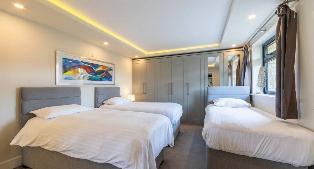 Spacious bedroom at Retreat 12 offering a double bed and 2 single beds, offering flexibility on your hen do