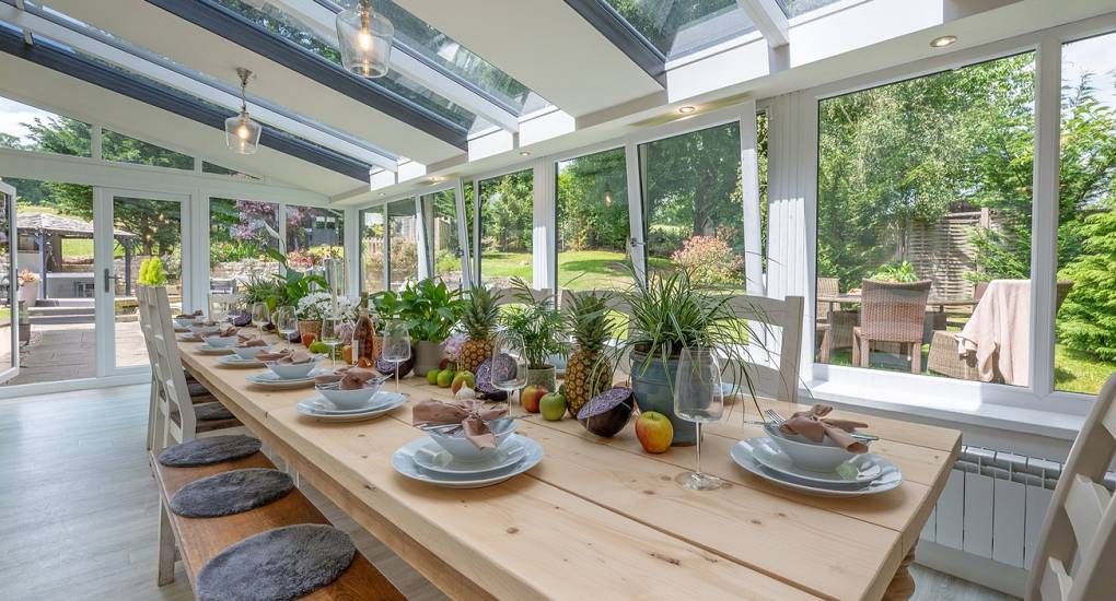 Large conservatory dining room at Summerset House: Luxury Bath hen party house with group seating for 24 and scenic garden views.