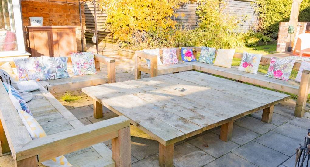 An oversized rustic wooden dining table at Tranquil Escape, providing ample social seating for a group of 22 to enjoy alfresco meals in the Newcastle countryside.
